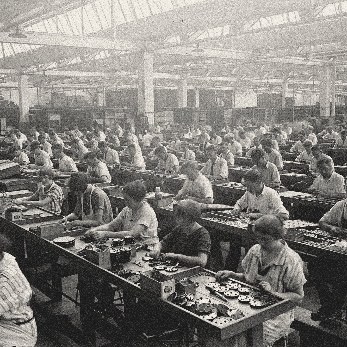 Un grand atelier de montage ancien : des rangées de personnes, chacune à son poste, penchées sur les mêmes gestes.
